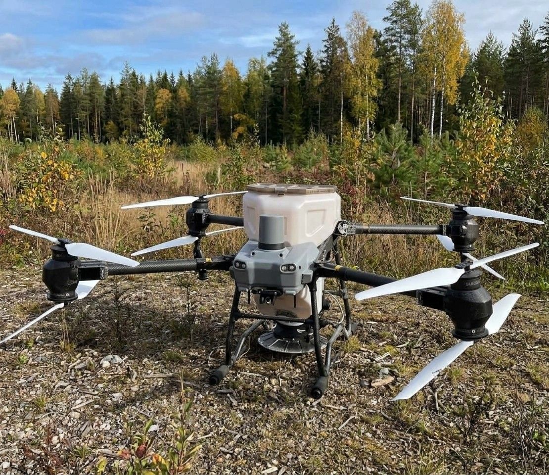 Lannoitteen levitykseen tarkoitettu drooni metsätien varressa, säiliö ja levitin näkyvissä
